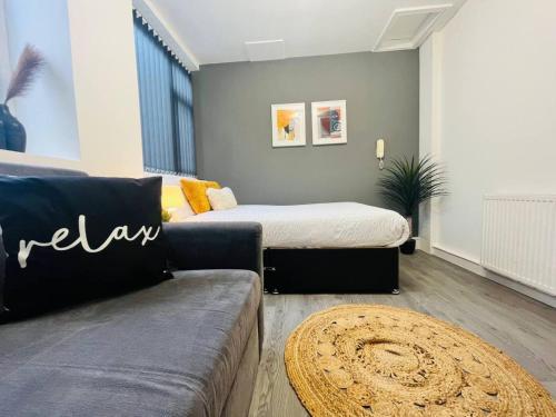 a living room with a bed and a couch at Centrally Located Stylish Studio Apt in Liverpool