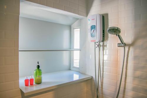 a bathroom with a shower with a bottle of wine on a shelf at CHADA HOUSE in Chiang Mai
