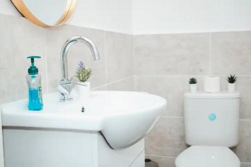 a white bathroom with a sink and a toilet at Elegant 4Bed House near the City Centre in Liverpool