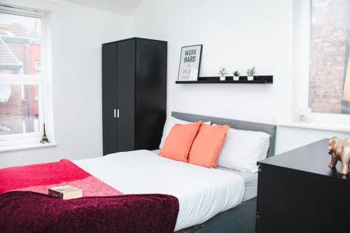 a bedroom with a bed and a black cabinet at Elegant 4Bed House near the City Centre in Liverpool