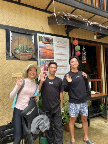 a group of three people standing in front of a building at Hidden of Cailan Extension Transient House in El Nido