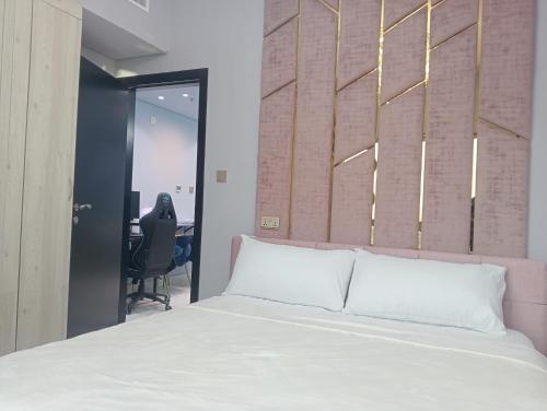 a bedroom with a white bed and a desk at Mag5 in Dubai