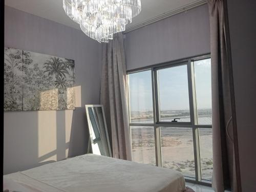 a bedroom with a large window and a chandelier at Mag5 in Dubai