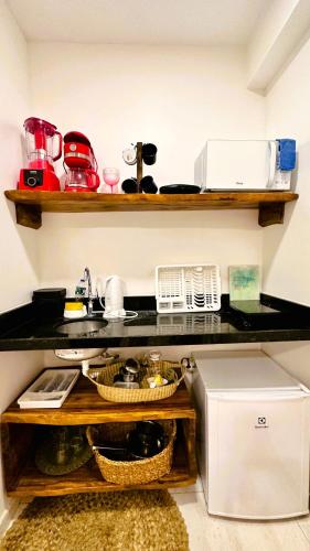 a kitchen with a counter top with dishes on it at Suítes Jardins de Flecheiras in Flecheiras