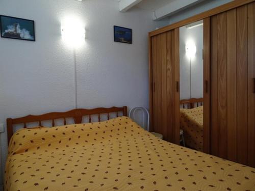 - une chambre avec un lit doté d'une couette jaune et d'un miroir dans l'établissement Pavillon rénové à 500m de la plage avec terrasse et parking privé à Argelès-sur-Mer - FR-1-776-53, à Argelès-sur-Mer