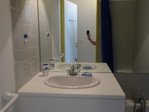 une personne prenant une photo d'un lavabo dans la salle de bains dans l'établissement Studio Climatisé Port Argelès: 3 Pers, Loggia, Parking, Plage & Commerces à Proximité - FR-1-776-62, à Argelès-sur-Mer