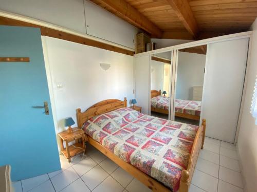 une chambre avec un lit et un miroir dans l'établissement Maison Type 2 avec Piscine Chauffée, Tennis et Proximité Bord de Mer à Brétignolles - FR-1-231-306, à Bretignolles-sur-Mer