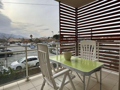 d'une table et de chaises sur un balcon avec vue sur le parking. dans l'établissement Appartement calme 2 pièces avec terrasse et parking, proche plage à Argelès-sur-Mer - FR-1-225-803, à Argelès-sur-Mer