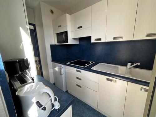 a small kitchen with white cabinets and a sink at Appartement Mandelieu-la-Napoule, 1 pièce, 2 personnes - FR-1-609-92 in Mandelieu-La Napoule