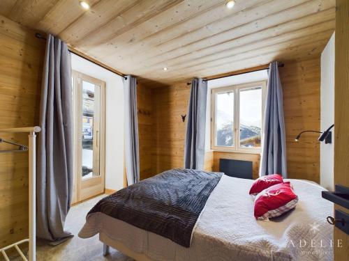 a bedroom with a bed with red pillows on it at Appartement Montvalezan-La Rosière, 6 pièces, 6 personnes - FR-1-398-662 in Montvalezan