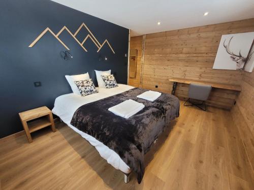 a bedroom with a large bed and a wooden wall at Chalet Les Gets, 8 pièces, 14 personnes - FR-1-598-161 in Les Gets