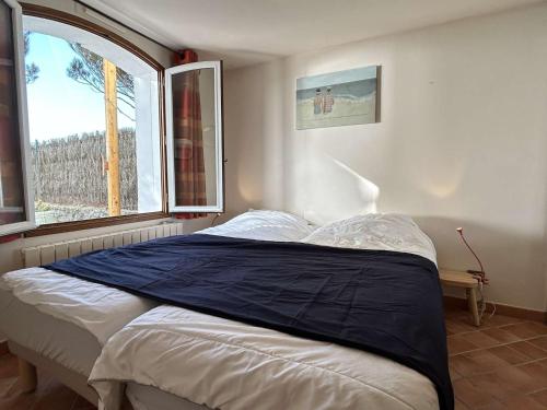 ein Bett in einem Zimmer mit einem großen Fenster in der Unterkunft Maison confortable face à la mer, 7 couchages, terrasse, jardin, wifi, parking, animaux acceptés - FR-1-224B-211 in La Guérinière