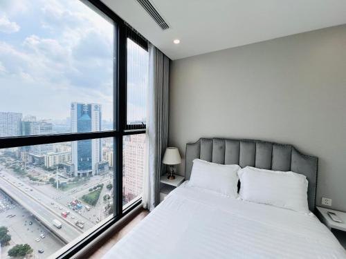 a bedroom with a bed and a large window at Vinhomes Sky Lake Phạm Hùng View Keangnam in Hanoi