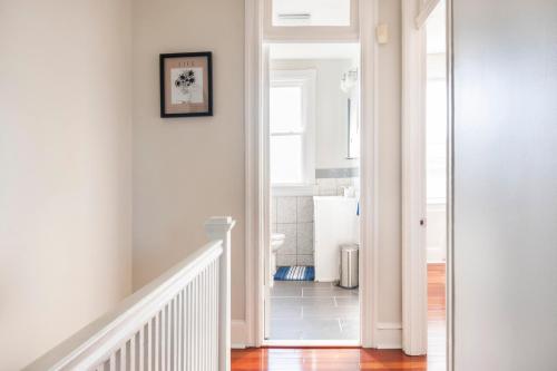 a hallway with white walls and a white stairway with a stair at Charming 4 Bedroom House!1 Mile from Capitol Hill! in Washington, D.C.