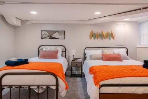 2 letti in una camera da letto con arancione e bianco di Charming 4 Bedroom House!1 Mile from Capitol Hill! a Washington