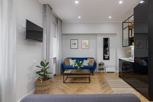 Una sala de estar con un sofá azul y una mesa. en Feel Lviv! Old City Apartment, en Leópolis
