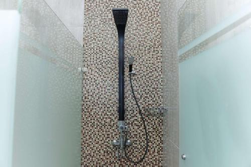 een douche met een douchekop in de badkamer bij 555 Nangka Guest House in Jakarta