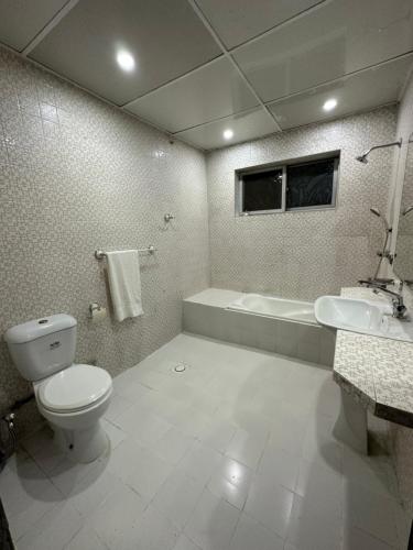 uma casa de banho com um WC, uma banheira e um lavatório. em Aleph Islamabad Guest House em Islamabad