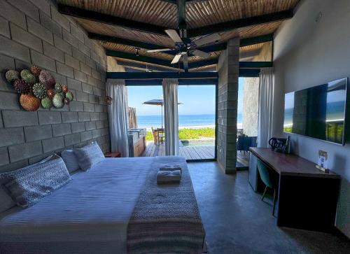 a bedroom with a bed and a view of the ocean at DIEM Vichayito Beachfront Eco-Luxury in Vichayito