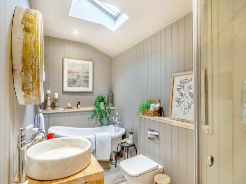a bathroom with a tub and a toilet and a sink at Appleby Barn in Lacock