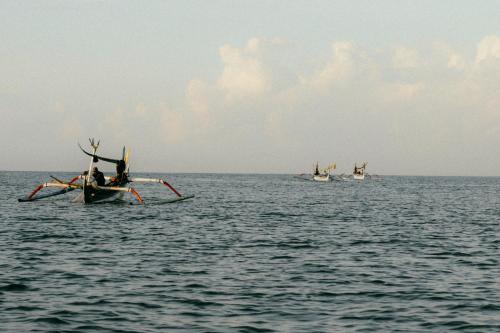 un grupo de barcos en el océano sobre el agua en Bombora Medewi en Pulukan