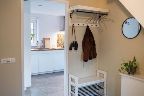 a kitchen with white cabinets and a mirror at Vakantiehuis Vliegend Hert Veluwe in Nunspeet