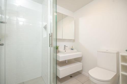 a white bathroom with a toilet and a sink at Harbor View Two Bedroom Apartment At Pinnacle in Wellington