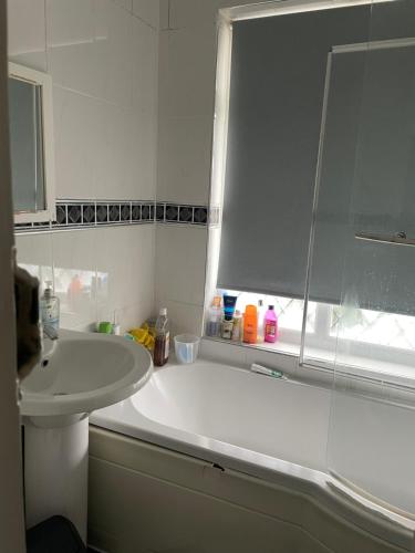 a bathroom with a white tub and a sink at B&B in Luton