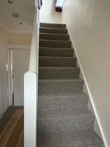 eine Treppe in einem Haus mit grauem Teppich in der Unterkunft B&B in Luton