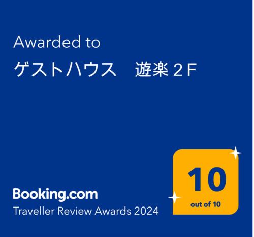 a yellow sign with the words awarded to travel review awards at ゲストハウス　遊楽２F in Osaka
