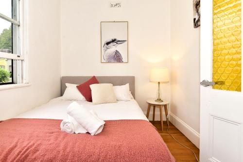 a bedroom with a bed with a red blanket at Sunny Apartment in Surry Hills in Sydney