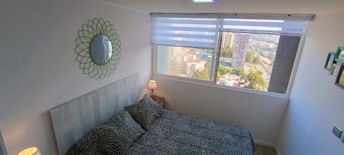 a bedroom with a bed and a large window at Vive Alto Reñaca in Viña del Mar