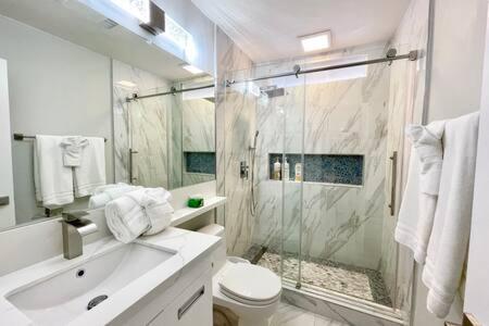 a bathroom with a shower and a toilet and a sink at Rainforest Villa 4 Bedroom PoolSpa Walk2Disneyland in Anaheim