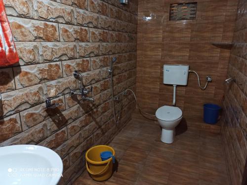 baño con aseo y pared de piedra en Shangri-La The Heritage Haveli en Jodhpur