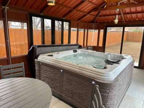 a large hot tub in a patio with a table at Springtime Family Oasis 5br House With Hot Tub in Bethany