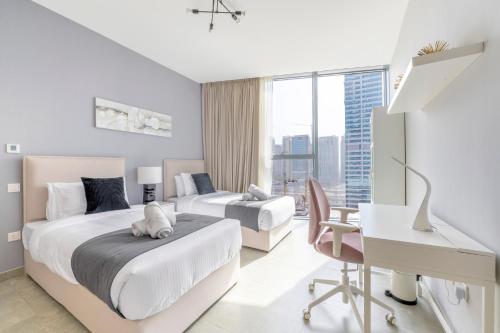 a hotel room with two beds and a desk and a desk at Ultra Luxury Dubai Marina - Stella Maris Tower in Dubai