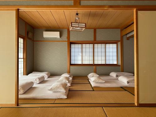 a room with four beds in it with windows at 山水民宿 in Takayama