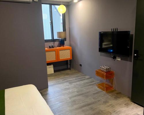 a room with a flat screen tv and a desk at Shanlin INN in Hualien City