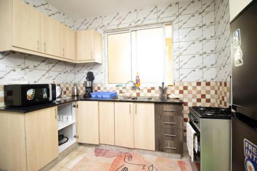 a kitchen with a sink and a microwave at Arabel 1 Bedroom D5 Kishan Towers, Nanyuki in Nanyuki