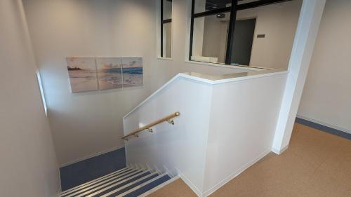 a staircase in a building with a white wall at MAHHO TERRACE MIYAKO in Miyako Island