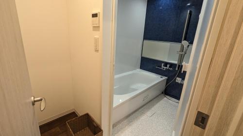 ein Badezimmer mit einer Badewanne und einer weißen Badewanne in der Unterkunft MAHHO TERRACE MIYAKO in Miyako-jima