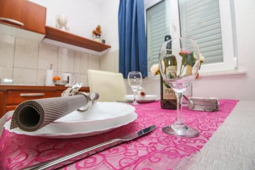 una mesa con un plato y una copa de vino en ella en Apartments Šara - free parking, en Primošten