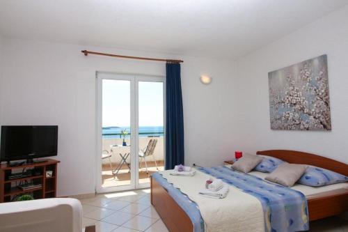 1 dormitorio con cama y vistas al océano en Apartments Šara - free parking, en Primošten