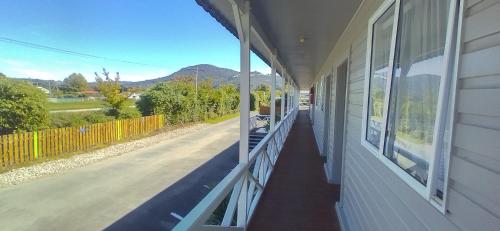 a porch of a house with a view of a street at Cosy Cottage Thermal Holiday Park in Rotorua