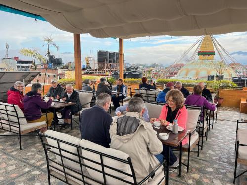 a group of people sitting at tables on a roof at Hotel Bodhiz in Kathmandu