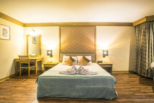 um quarto de hotel com uma cama com uma toalha em โรงแรมมุกดาหารแกรนด์ 