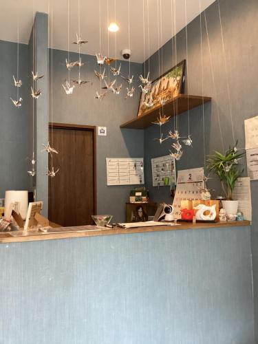 a counter with paper birds hanging from the ceiling at Osaka Namba Hostel MIYABI in Osaka