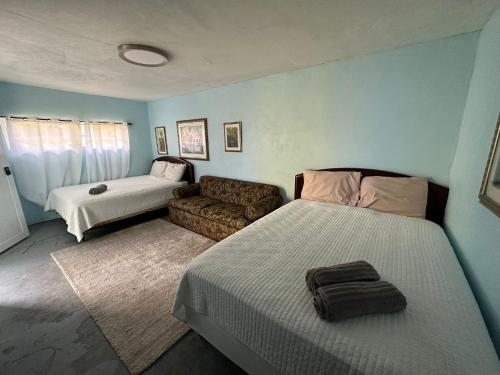 a living room with two beds and a couch at Beach Getaway with Cozy 2 Bedrooms near the Ocean, Arecibo in Arecibo