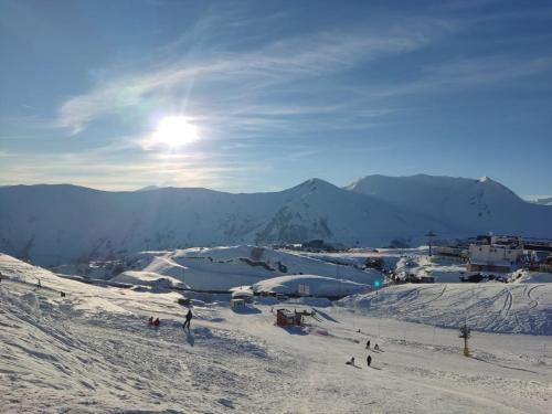 a group of people skiing down a snow covered slope at Evdo Apartments F2 Lovely Studio in Gudauri