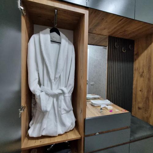 a white robe on a shelf in a bathroom at Evdo Apartments F2 Lovely Studio in Gudauri